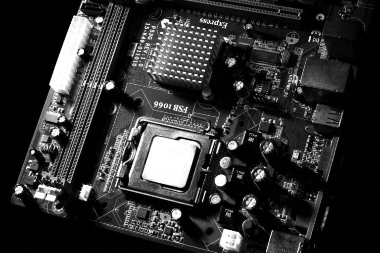 Monochrome detailed close-up of computer motherboard circuitry showcasing components and tech intricacies.